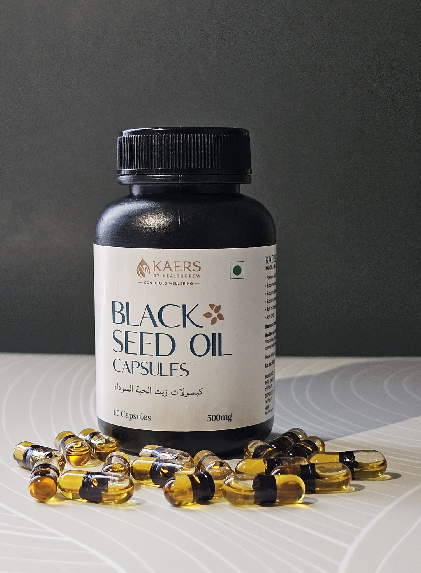 Black seed oil capsules bottle with scattered capsules on a gray background